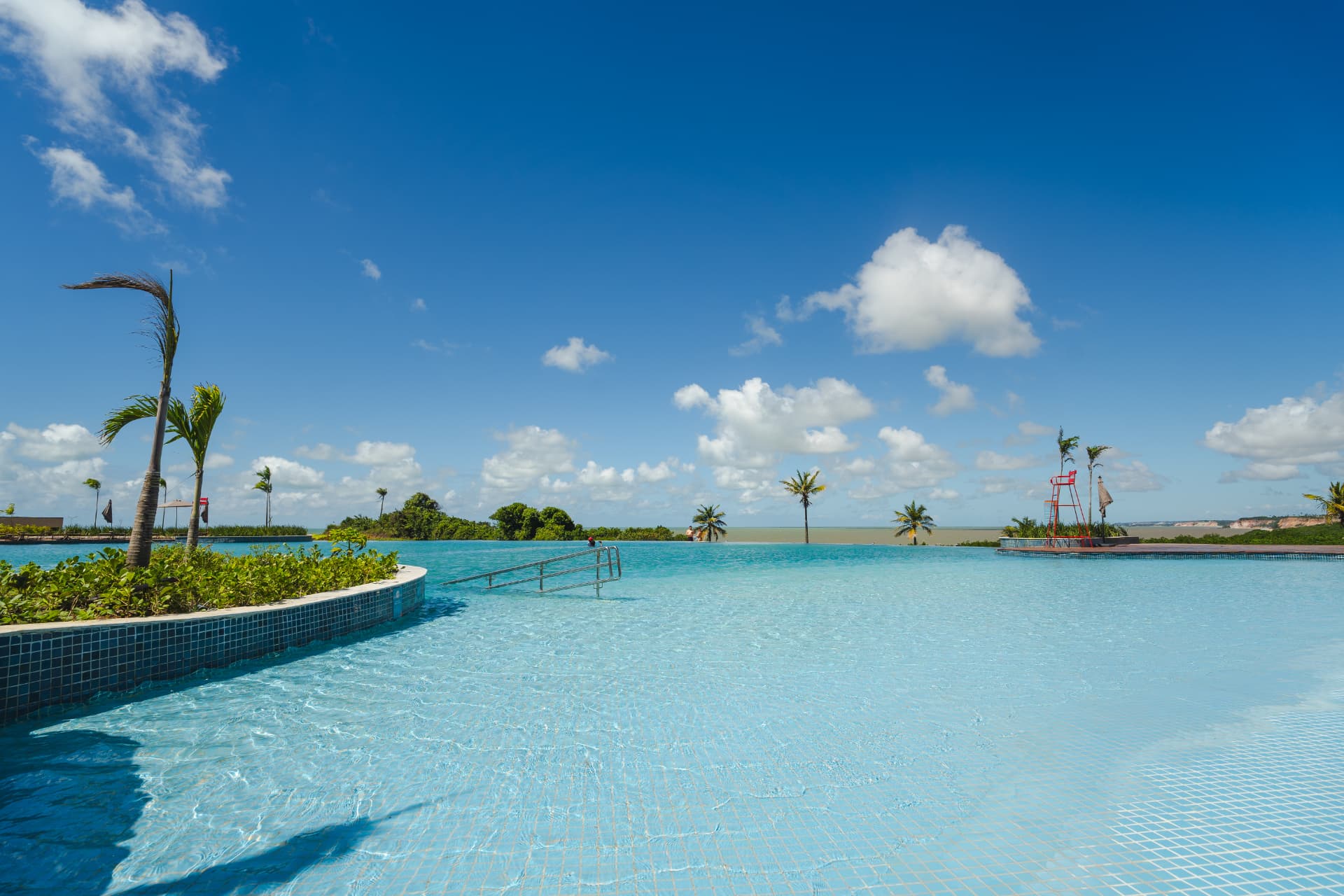 Área de lazer com piscina e coqueiros do Tauá Resort João Pessoa